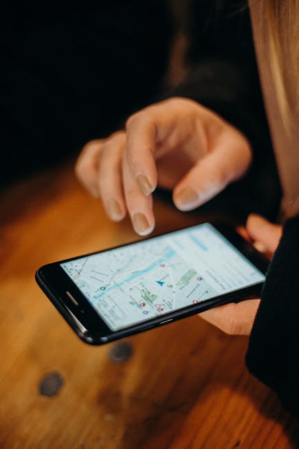 Main utilisant un smartphone pour une navigation sur une carte.